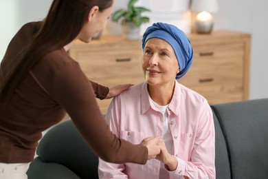 Caregiver helping woman with cancer at home