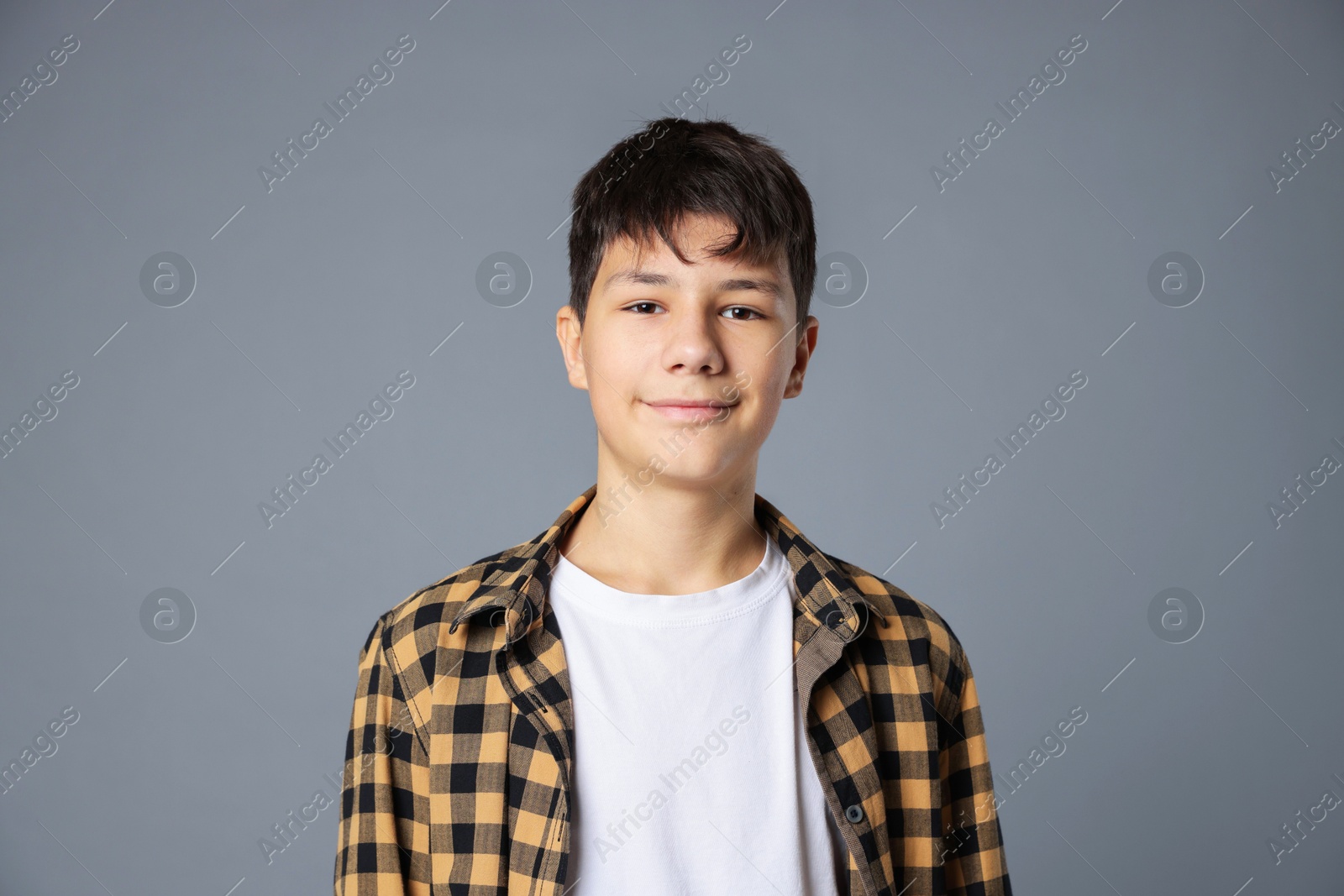 Photo of Portrait of teenage boy on grey background