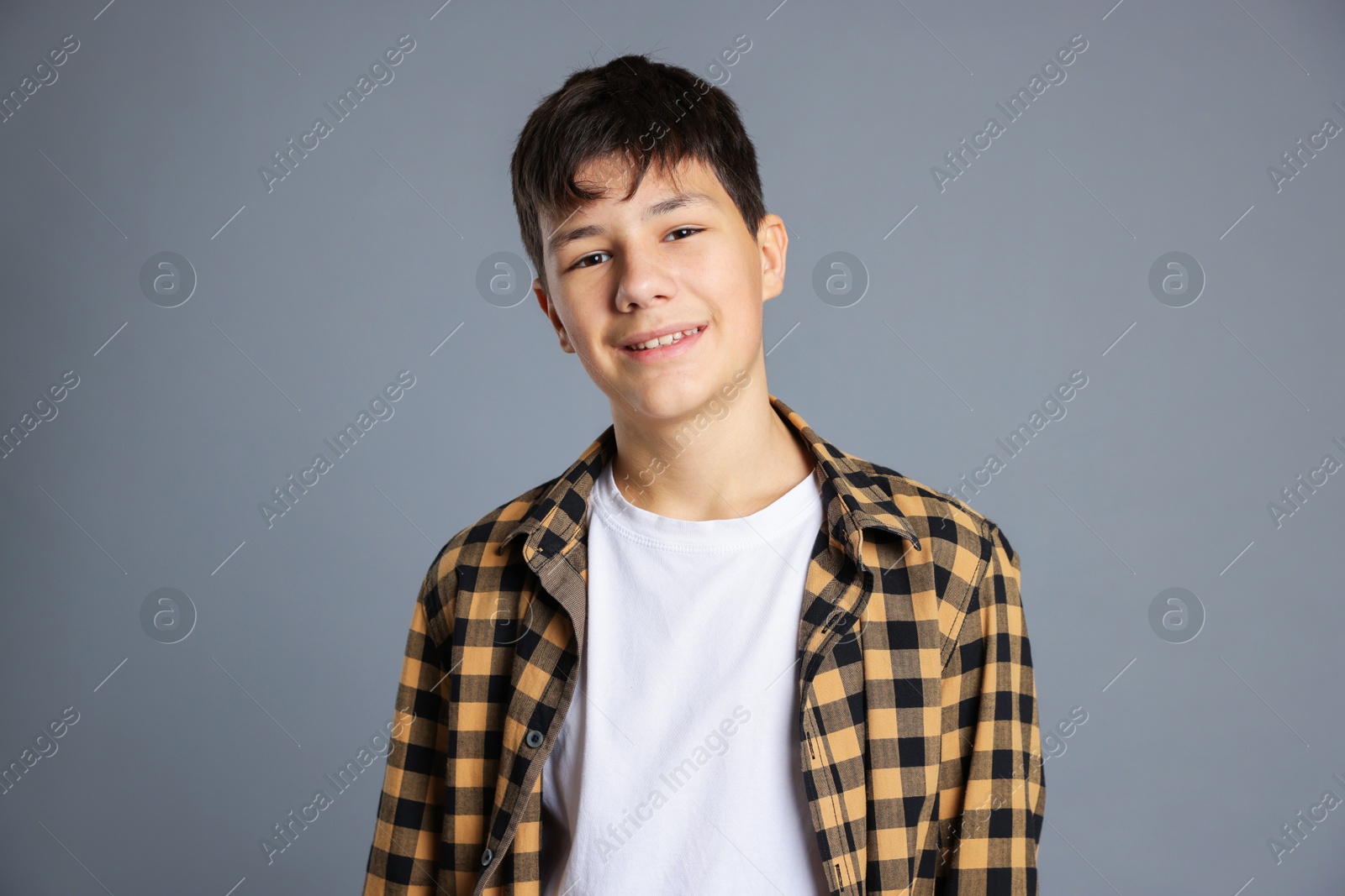 Photo of Portrait of teenage boy on grey background