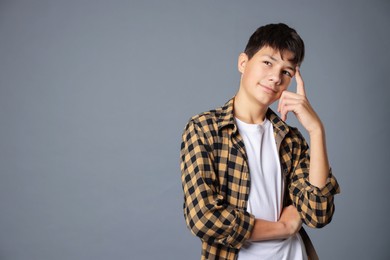 Photo of Portrait of teenage boy on grey background, space for text