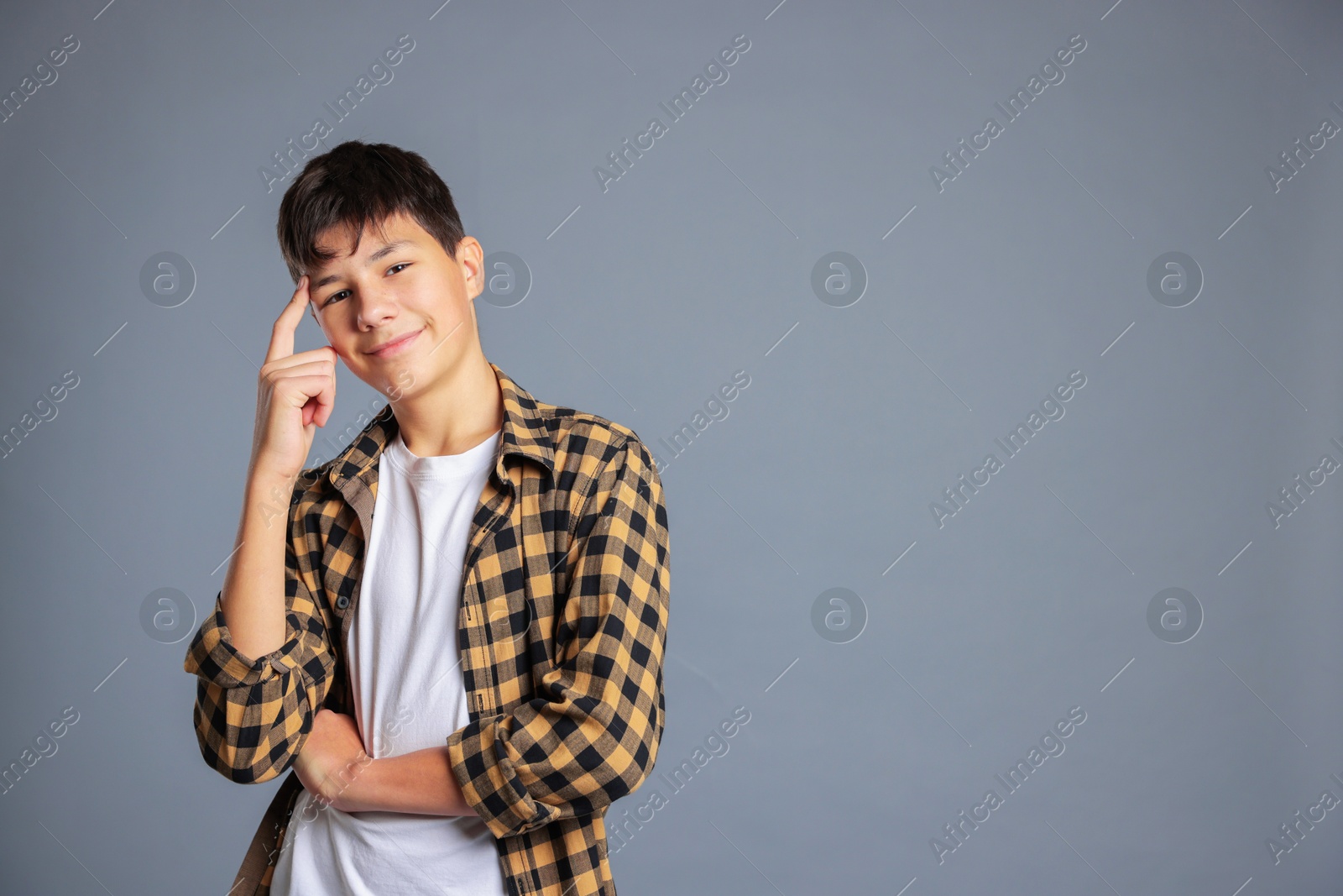 Photo of Portrait of teenage boy on grey background, space for text