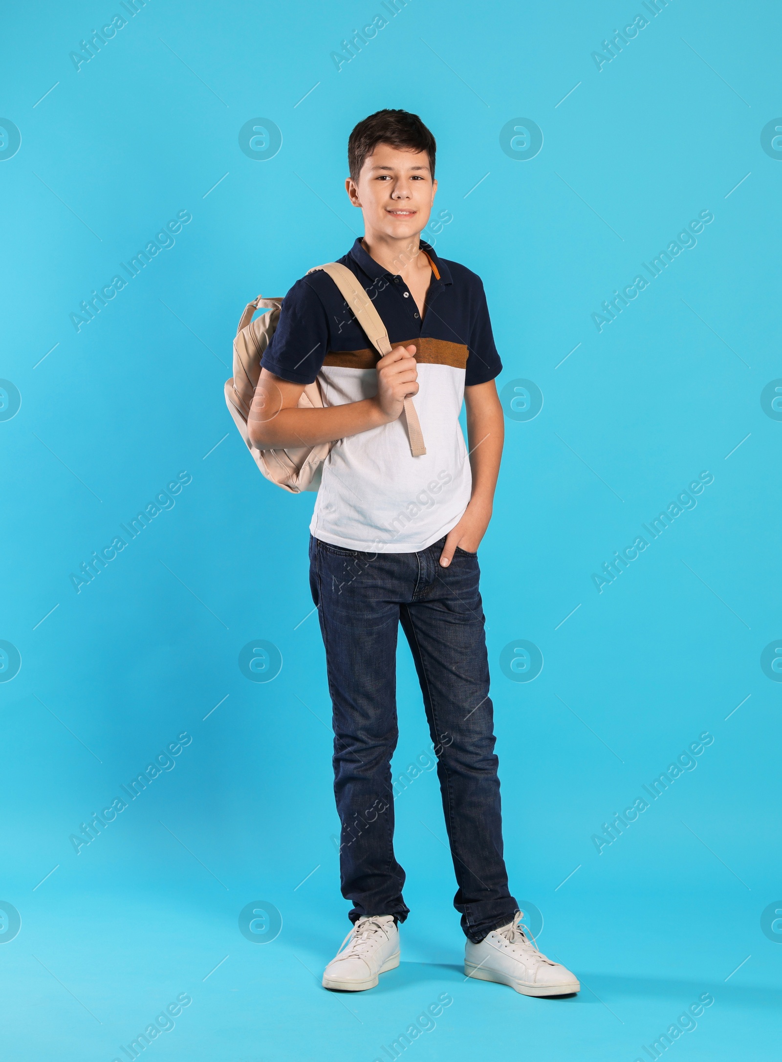 Photo of Full length portrait of teenage boy with backpack on light blue background