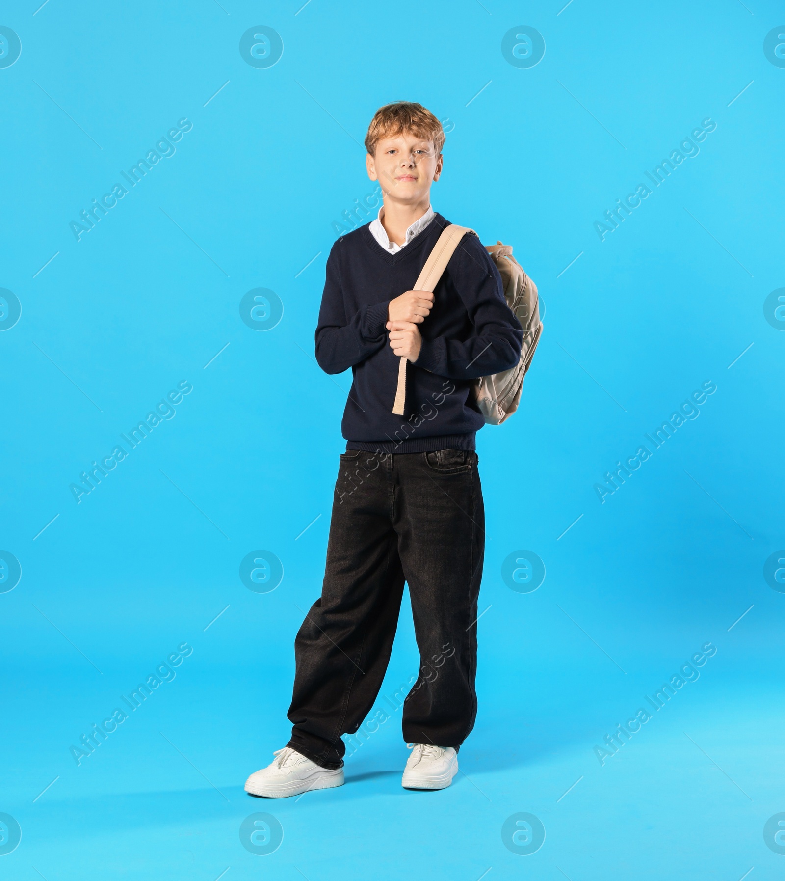 Photo of Full length portrait of teenage boy with backpack on light blue background