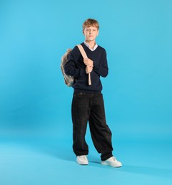 Photo of Full length portrait of teenage boy with backpack on light blue background