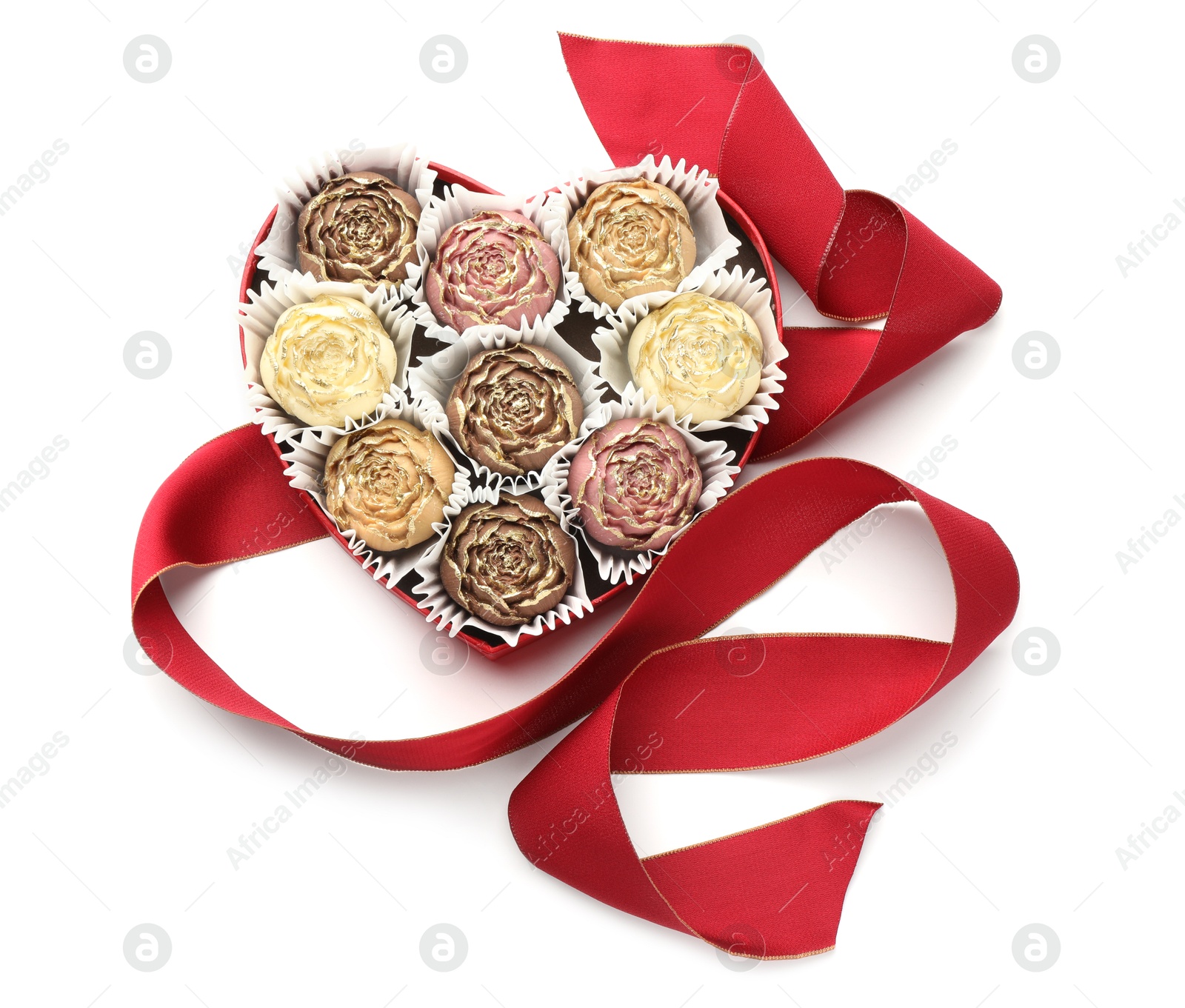 Photo of Flower shaped chocolate bonbons in box and red ribbon isolated on white, top view