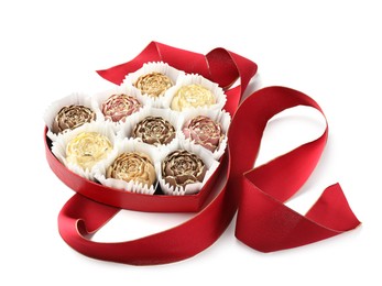 Photo of Flower shaped chocolate bonbons in box and red ribbon isolated on white