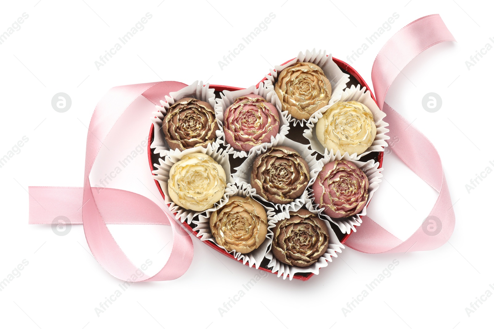 Photo of Flower shaped chocolate bonbons in box and pink ribbon isolated on white, top view