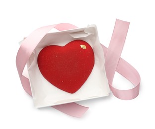 Photo of Heart shaped chocolate in box and pink ribbon isolated on white, top view