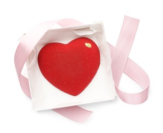 Photo of Heart shaped chocolate in box and pink ribbon isolated on white, top view