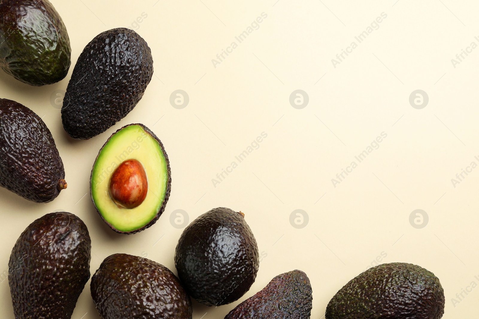 Photo of Fresh ripe avocados on beige background, flat lay. Space for text