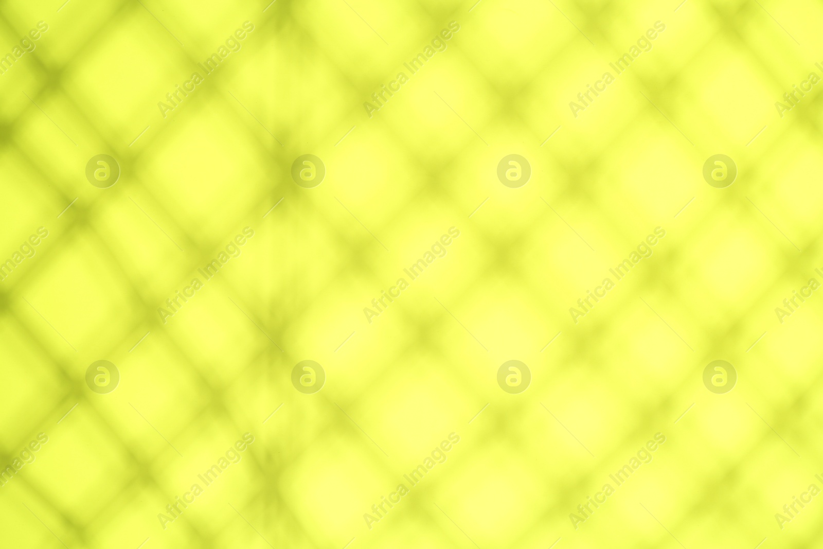 Photo of Light and shadows falling on yellow background