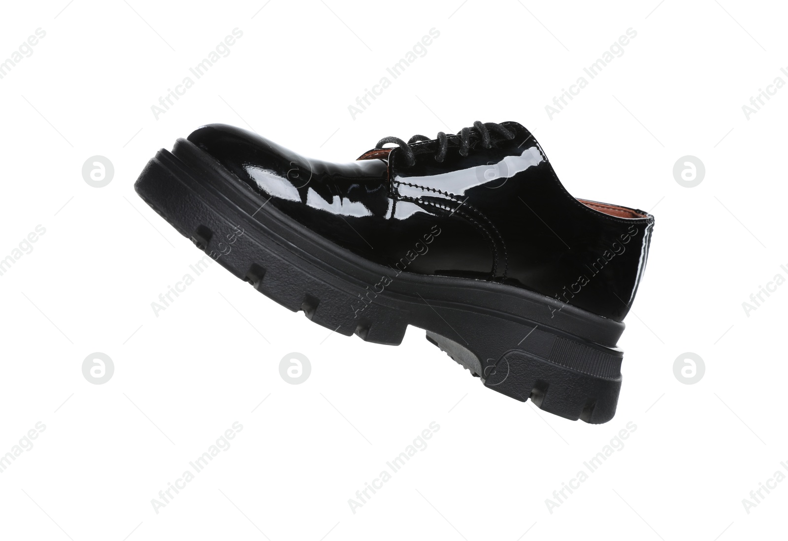 Photo of One black leather shoe in air isolated on white