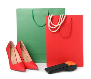 Photo of Payment terminal, shopping bags, necklace and heels isolated on white