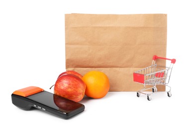 Photo of Payment terminal, shopping bag, fruits and mini cart isolated on white