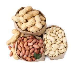 Photo of Different peanuts in paper bags isolated on white, top view
