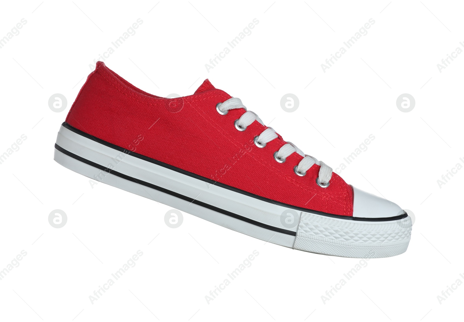 Photo of One red sneaker in air isolated on white