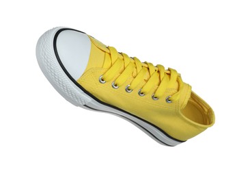 Photo of One yellow sneaker in air isolated on white