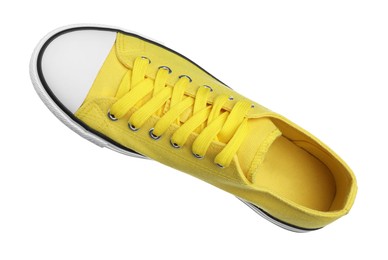 Photo of One yellow sneaker in air isolated on white