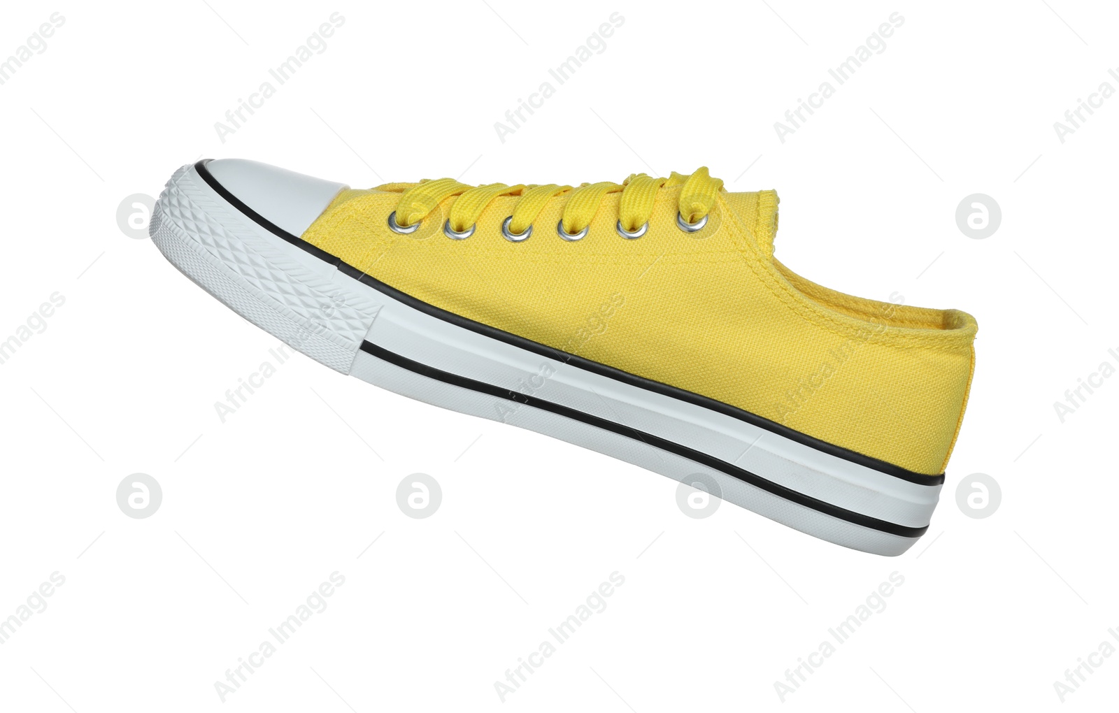 Photo of One yellow sneaker in air isolated on white