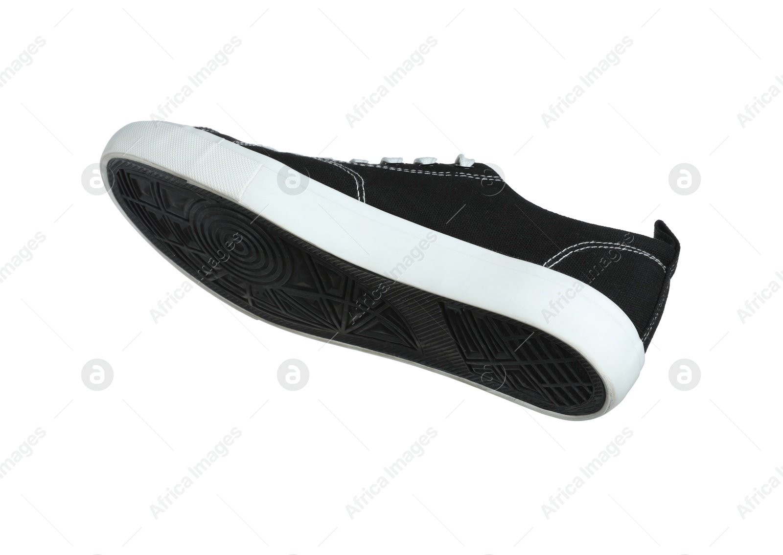 Photo of One black sneaker in air isolated on white