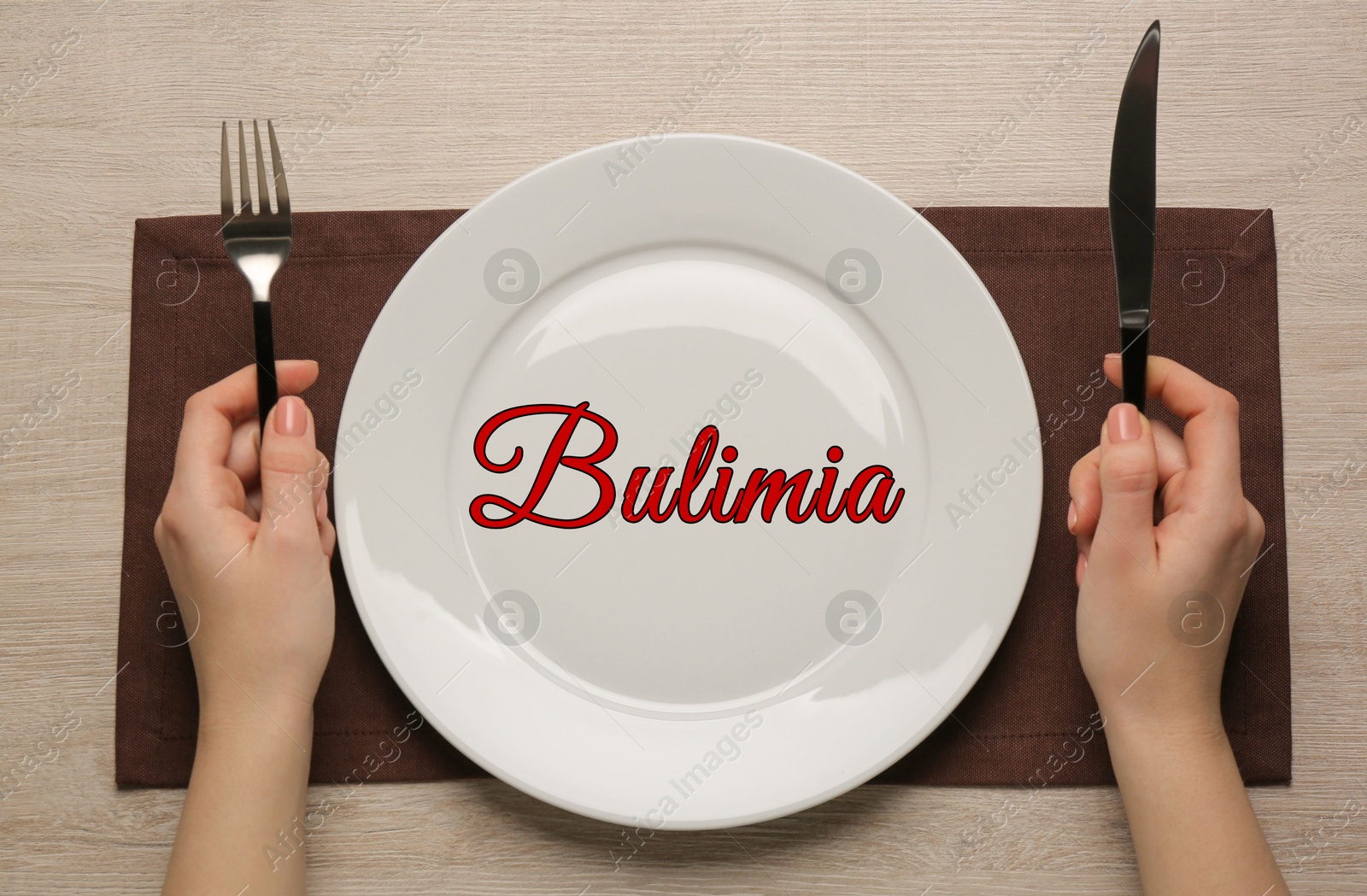 Image of Bulimia nervosa. Woman with empty plate and cutlery at wooden table, top view