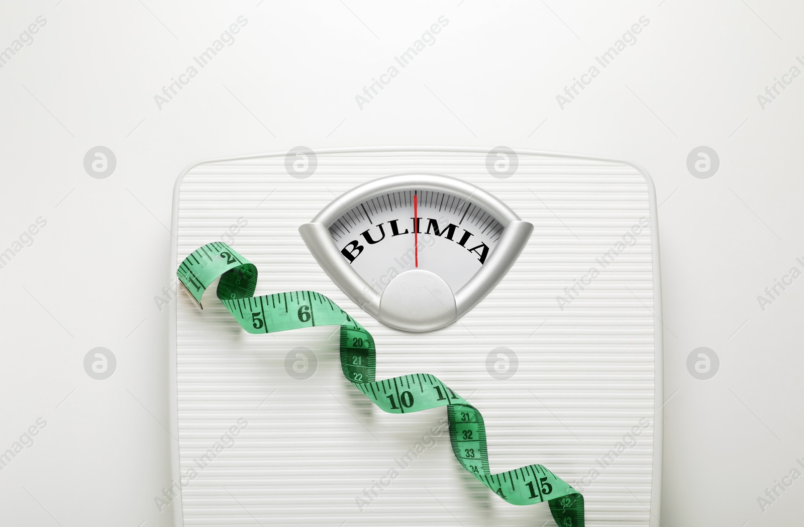 Image of Mechanical scales with word Bulimia instead of numbers and measuring tape on white background, top view