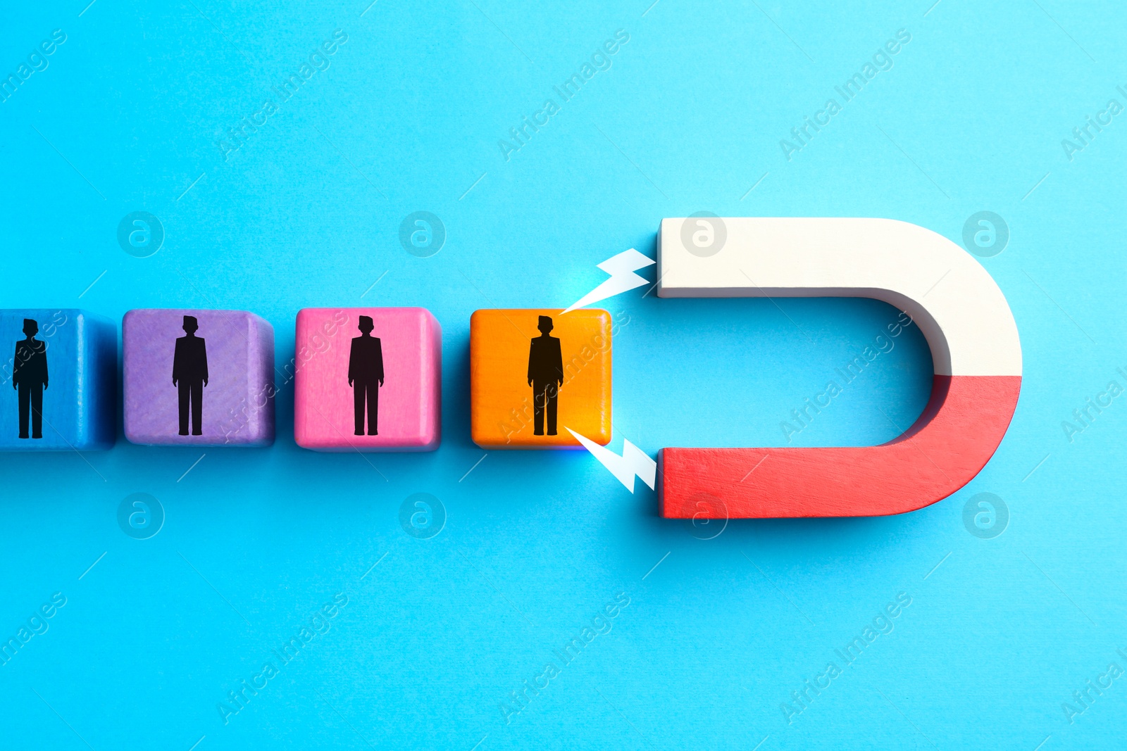 Image of Magnet attracting colorful cubes with human figures on light blue background, top view. Recruitment or customer acquisition