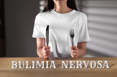 Image of Bulimia nervosa. Woman with cutlery at wooden table indoors, closeup