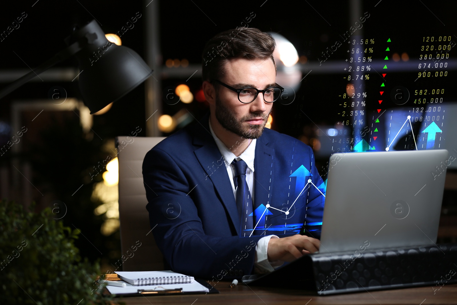 Image of Trading. Businessman working on laptop at night. Virtual screen with data and graph over computer