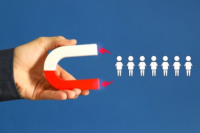 Image of Man attracting white human figures with magnet on blue background, closeup. Recruitment or customer acquisition