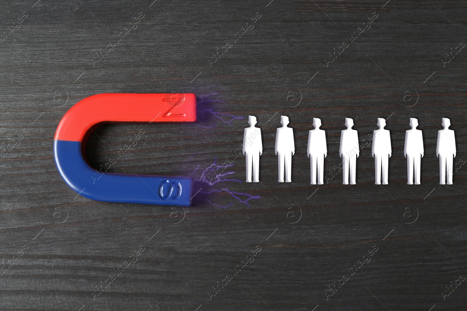 Image of Magnet attracting white human figures on wooden background, top view. Recruitment or customer acquisition