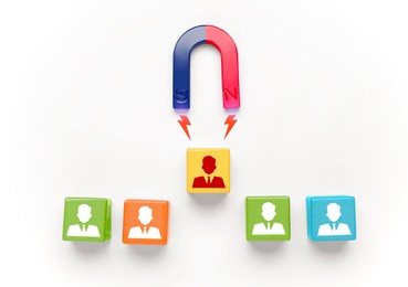 Image of Magnet attracting one of colorful cubes with human figures on light background, top view. Recruitment or customer acquisition