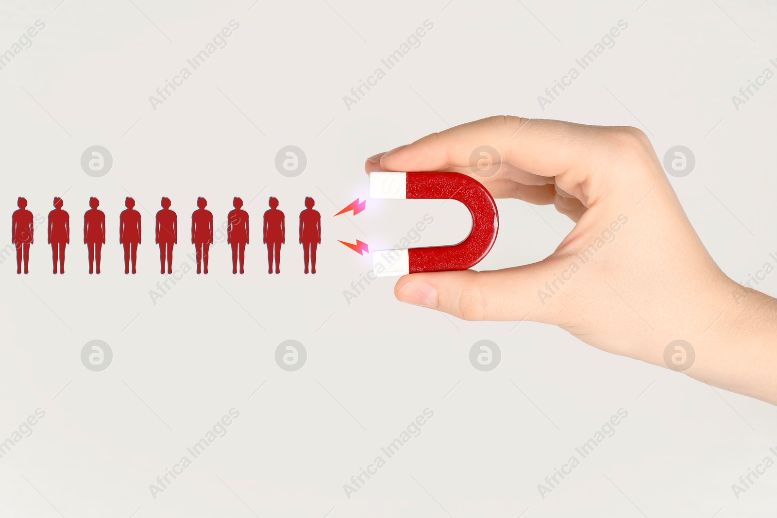 Image of Woman attracting red human figures with magnet on white background, closeup. Recruitment or customer acquisition