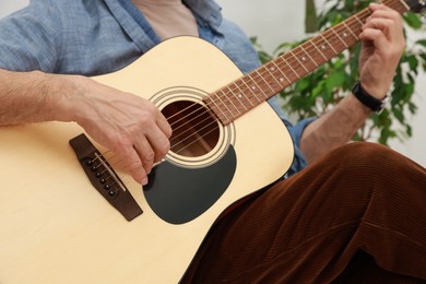 Photo of Relaxing hobby. Senior man playing guitar at home, closeup