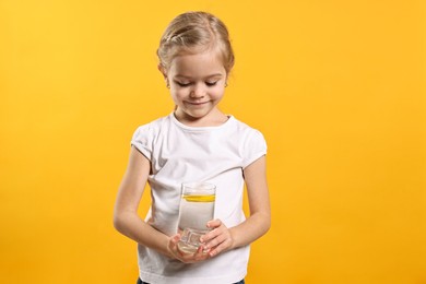 Photo of Girl with glass of lemonade on orange background. Refreshing drink