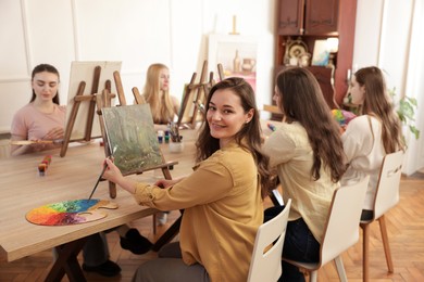 Group of women learning to draw at table in class