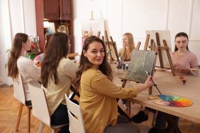 Photo of Group of women learning to draw at table in class