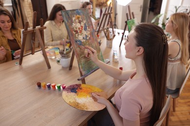 Photo of Group of women learning to draw at table in class