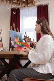 Photo of Woman with palette and brush learning to draw at table in class