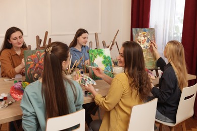 Group of women learning to draw at table in class