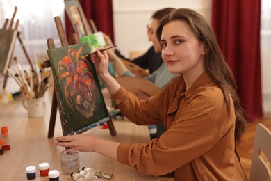 Photo of Group of women learning to draw at wooden table in class