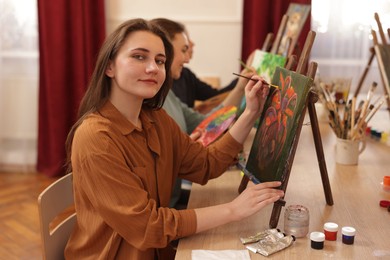 Photo of Group of women learning to draw at wooden table in class