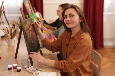 Photo of Group of women learning to draw at wooden table in class