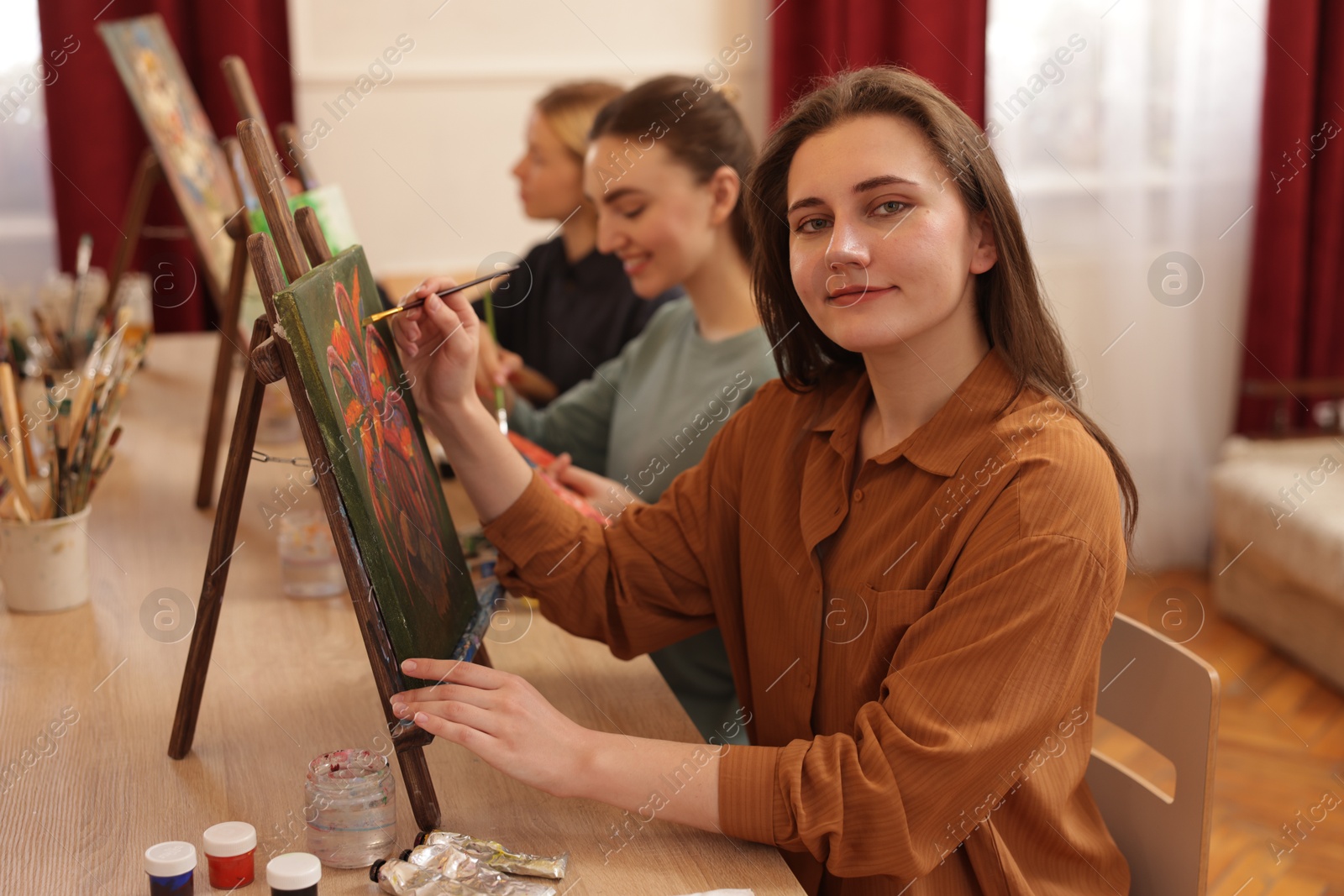 Photo of Group of women learning to draw at wooden table in class