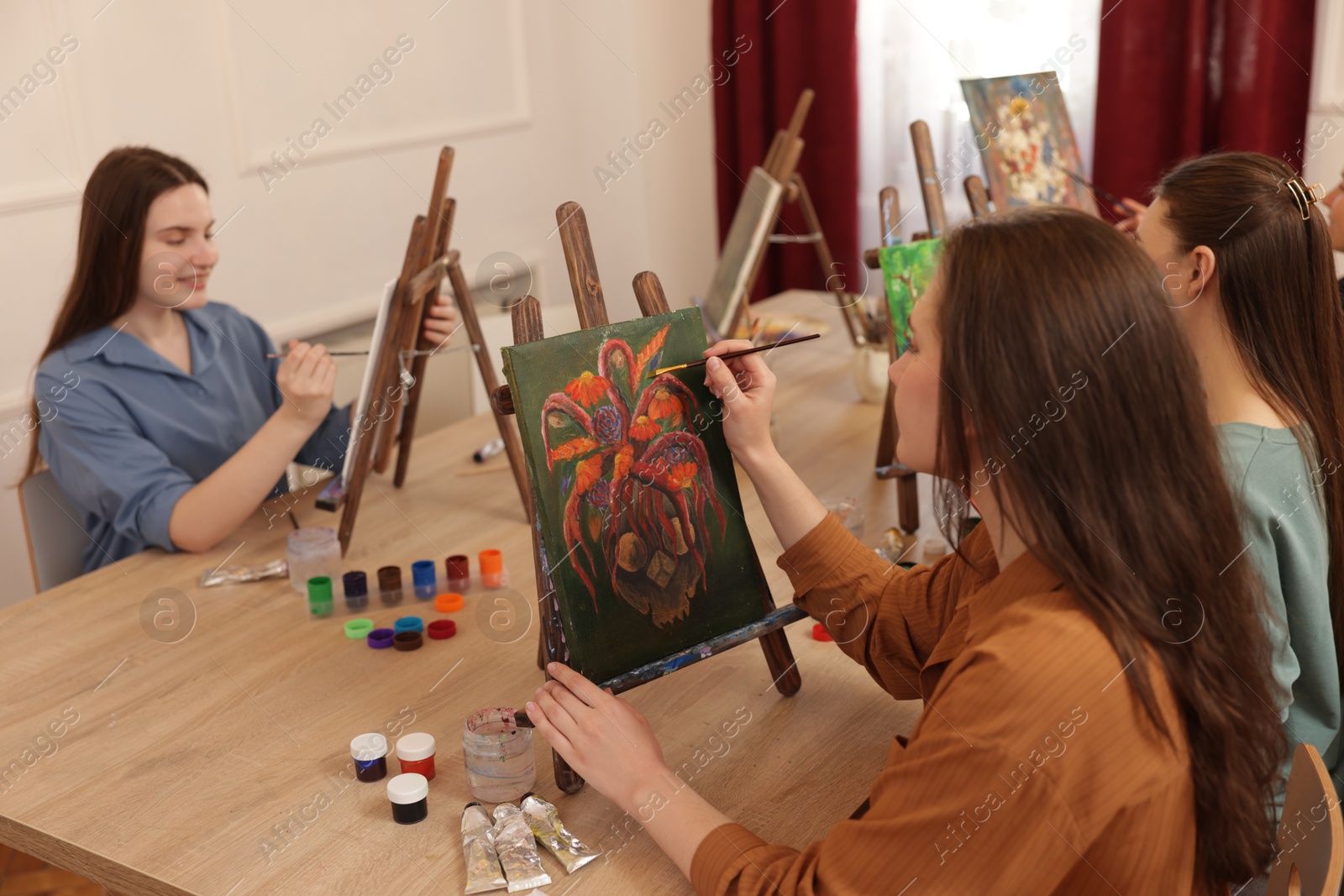 Photo of Group of women learning to draw at wooden table in class