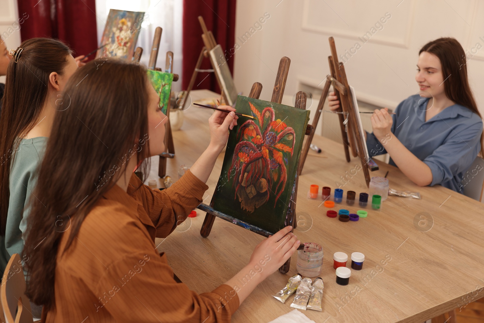 Photo of Group of women learning to draw at wooden table in class