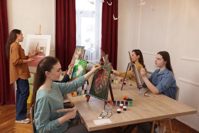 Group of women learning to draw at table in class