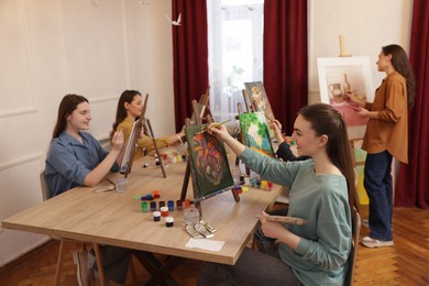 Photo of Group of women learning to draw at table in class