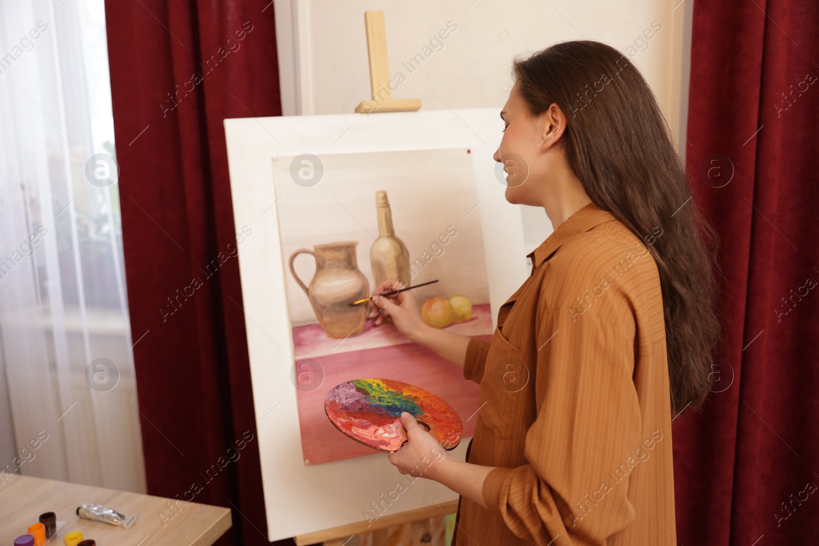 Photo of Woman with palette and brush learning to draw in class