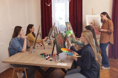 Group of women learning to draw at table in class